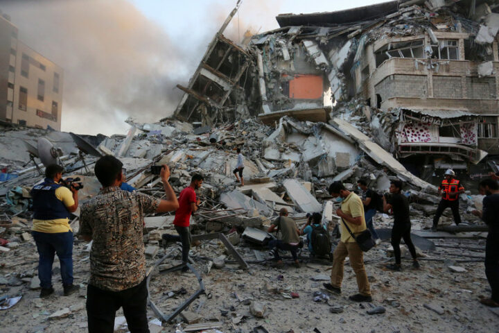 Palestinians inspect the rubble of al-Shurouk tower after it was hit by an Israeli airstrike on 12 May. Ashraf Amra APA images)