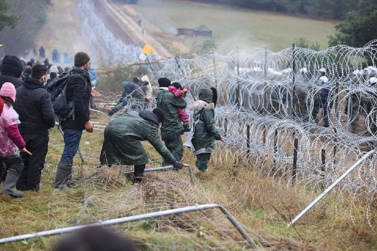 Image shows a family near a barbed wire fence